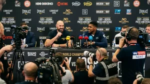 Boxing promotion press conference with network cameras and betting odds projected behind the fighters