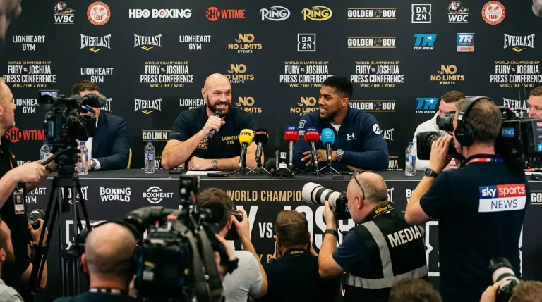 Boxing promotion press conference with network cameras and betting odds projected behind the fighters